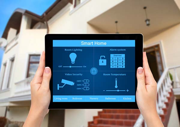 Female hands hold a tablet with system smart house on the backgr